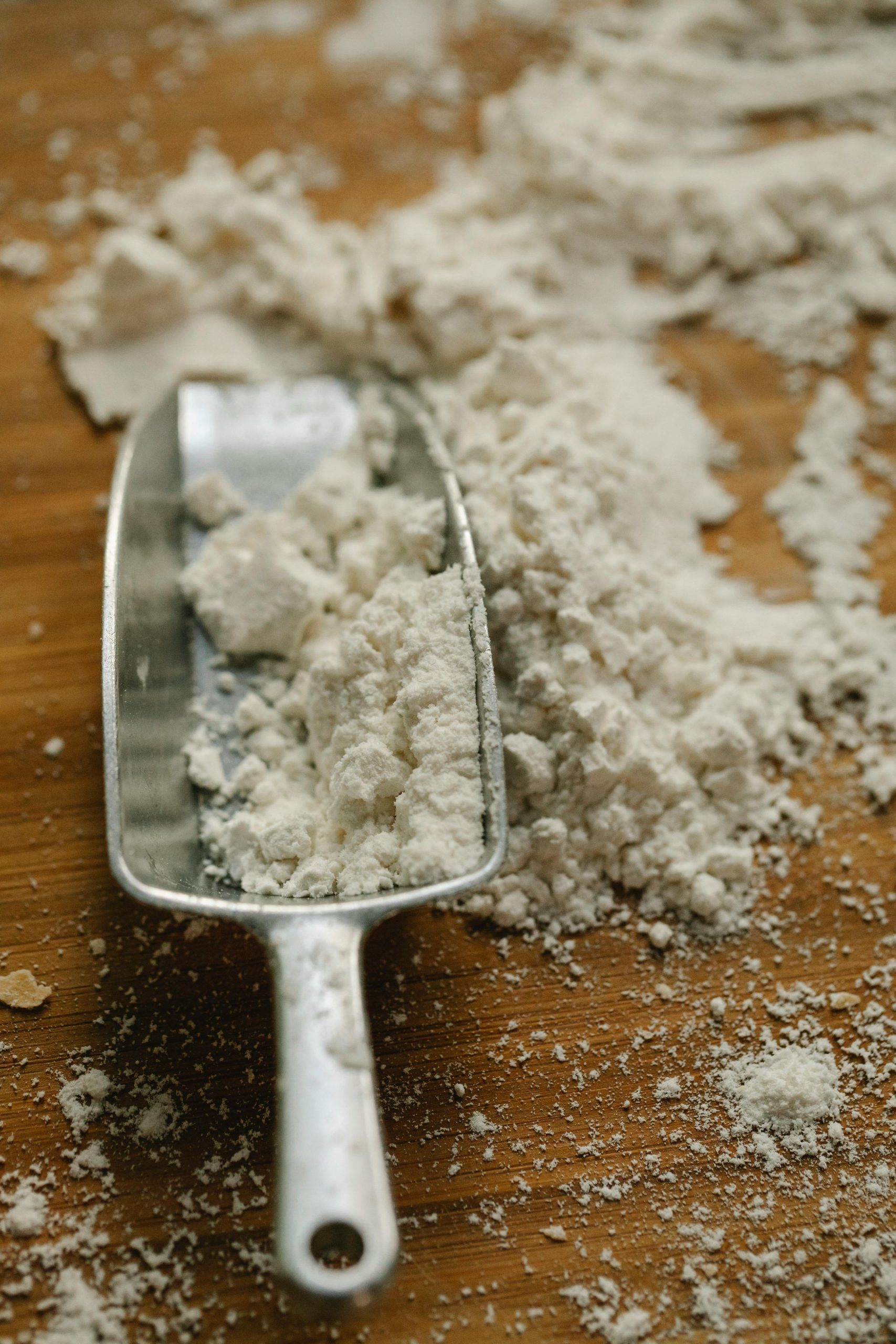 pexels-photo-6287320-6287320 From above of metal scoop with flour on wooden table with mess in house