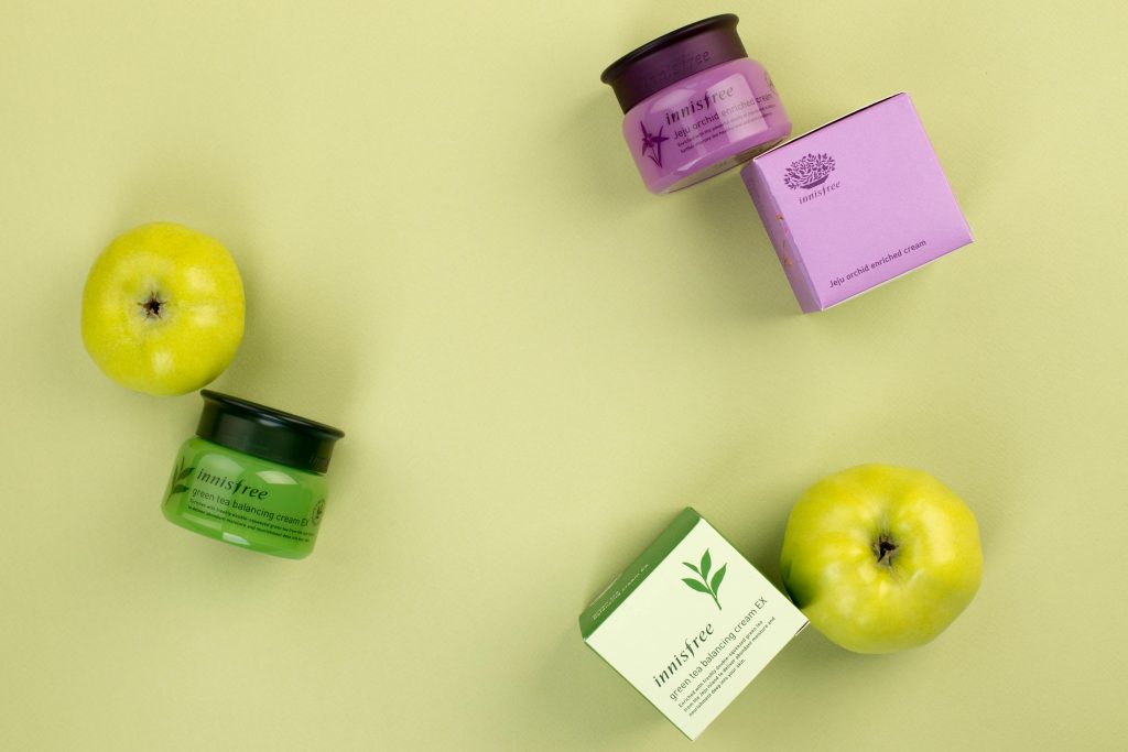 Colorful skincare products with green apples on a soft yellow background. Ideal for beauty and lifestyle themes.